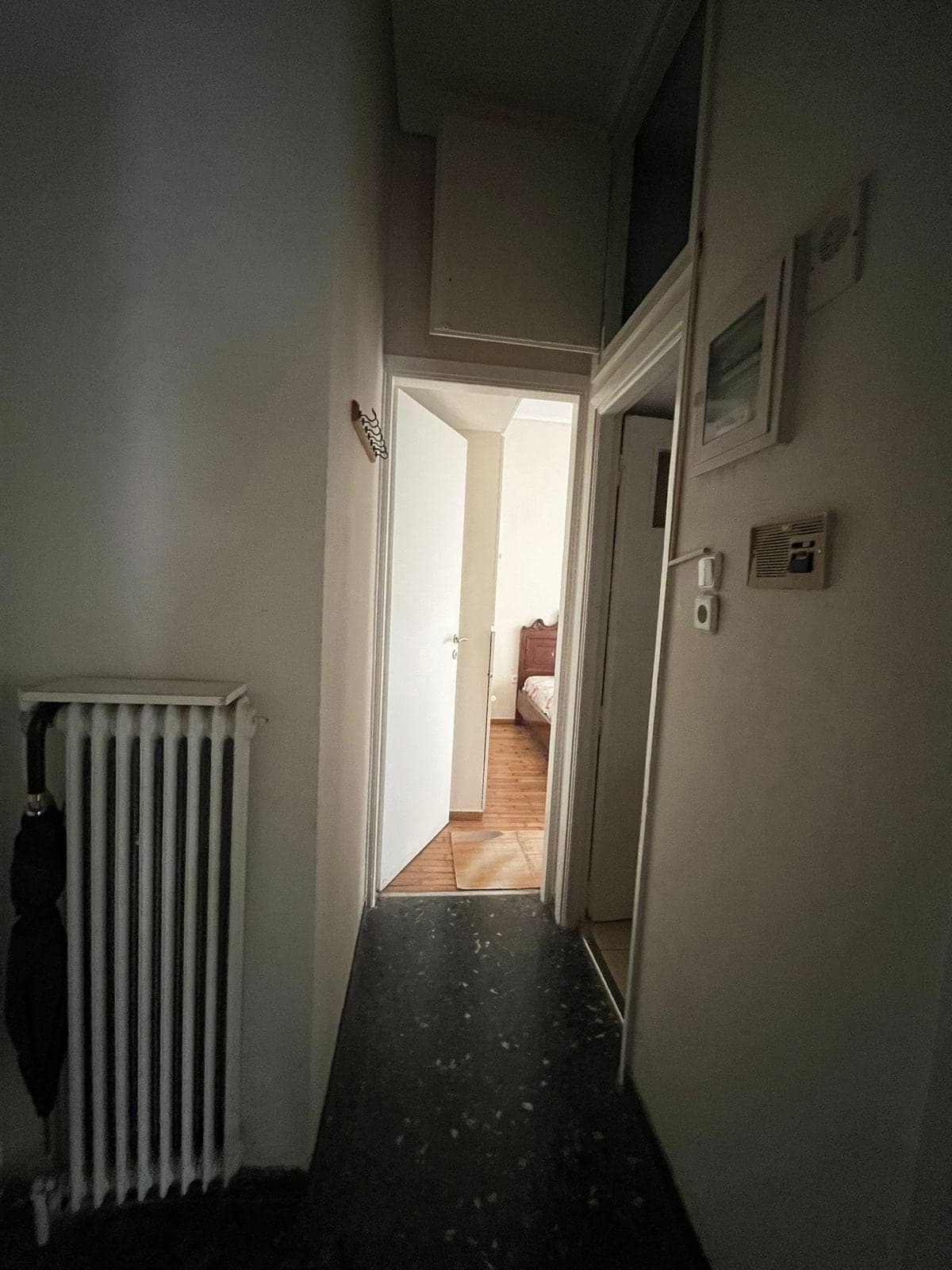 Ο διάδρομος πριν την ανακαίνιση, σκοτεινός, με παλιό καλοριφέρ και σκούρο δάπεδο