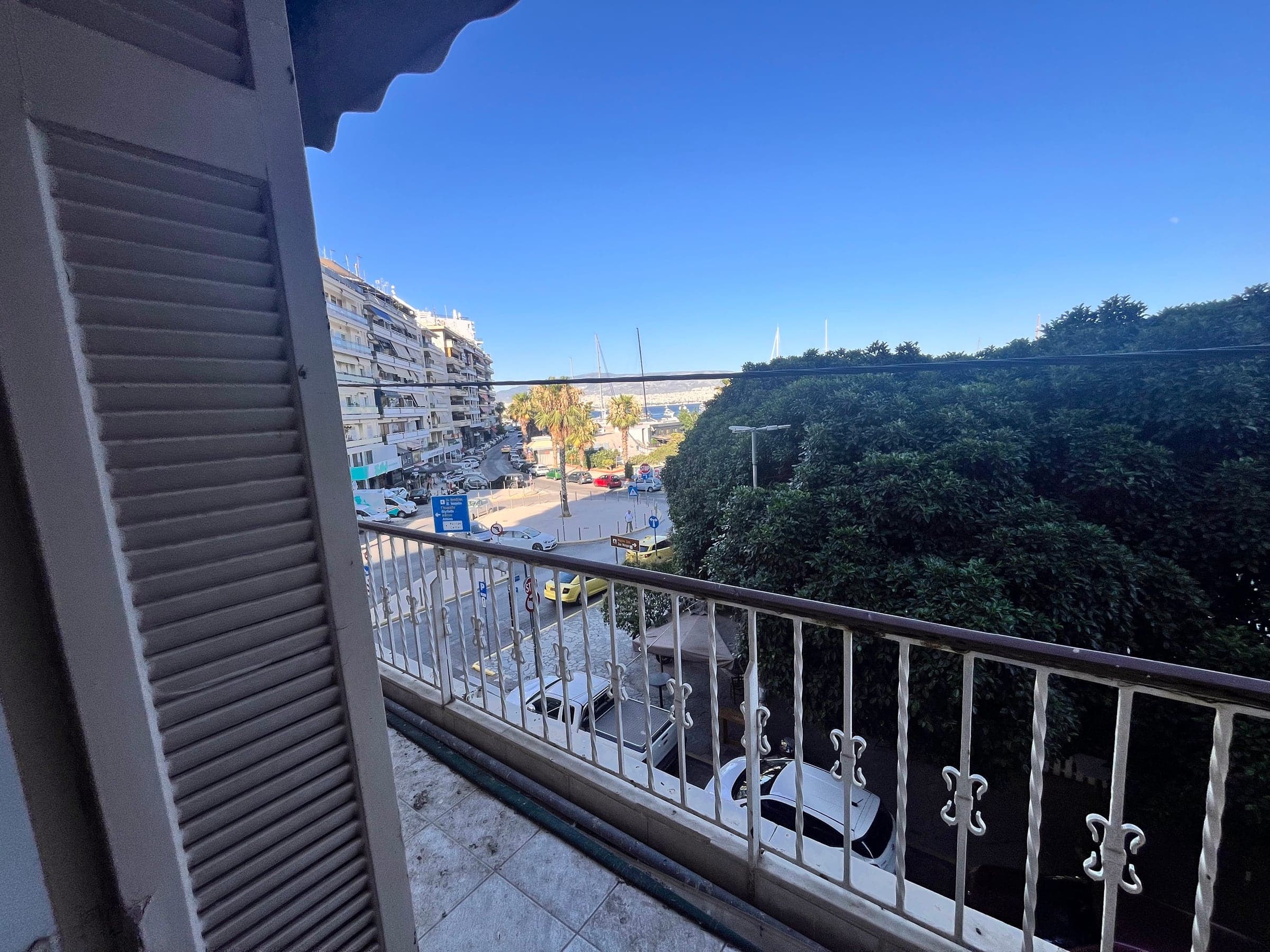 Balcony before renovation with worn shutters, looking towards the sea